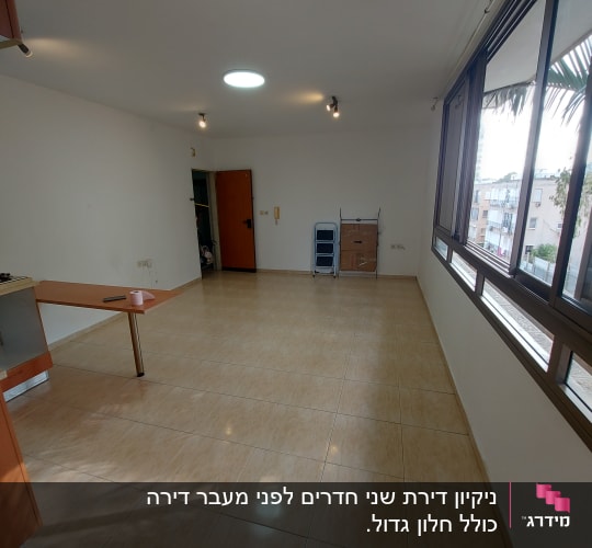 חדר ריק עם רצפה נקייה ומגב בפינה